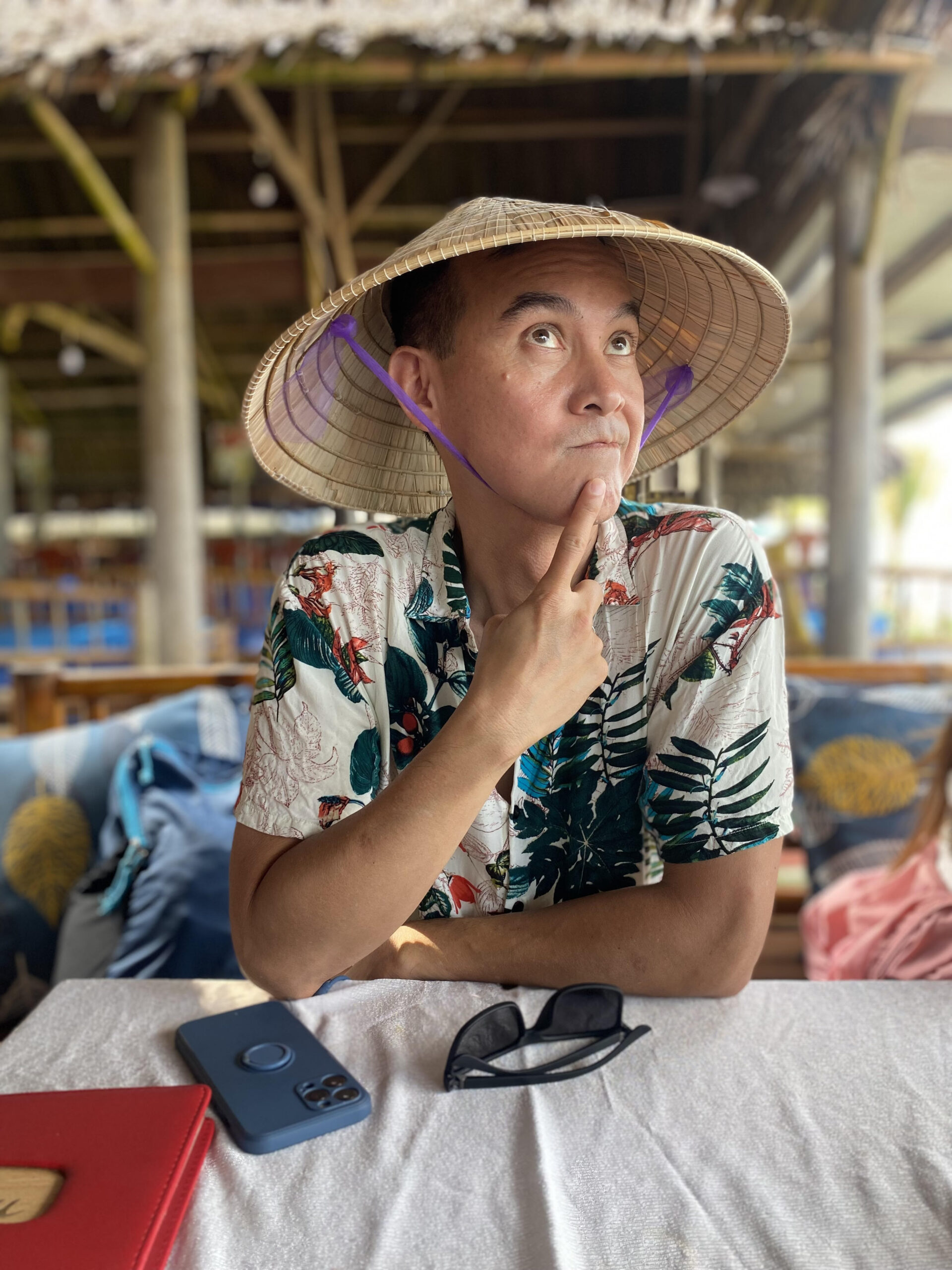 Paul wearing a traditional Vietnamese straw hat while waiting for lunch.